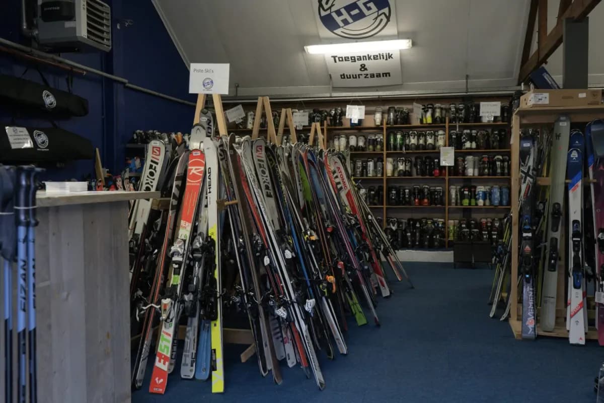 De winkel van HG Sports in Klundert: rekken vol tweedehands ski's en een wand met skischoenen